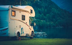 Photo of an RV parked by a lake.